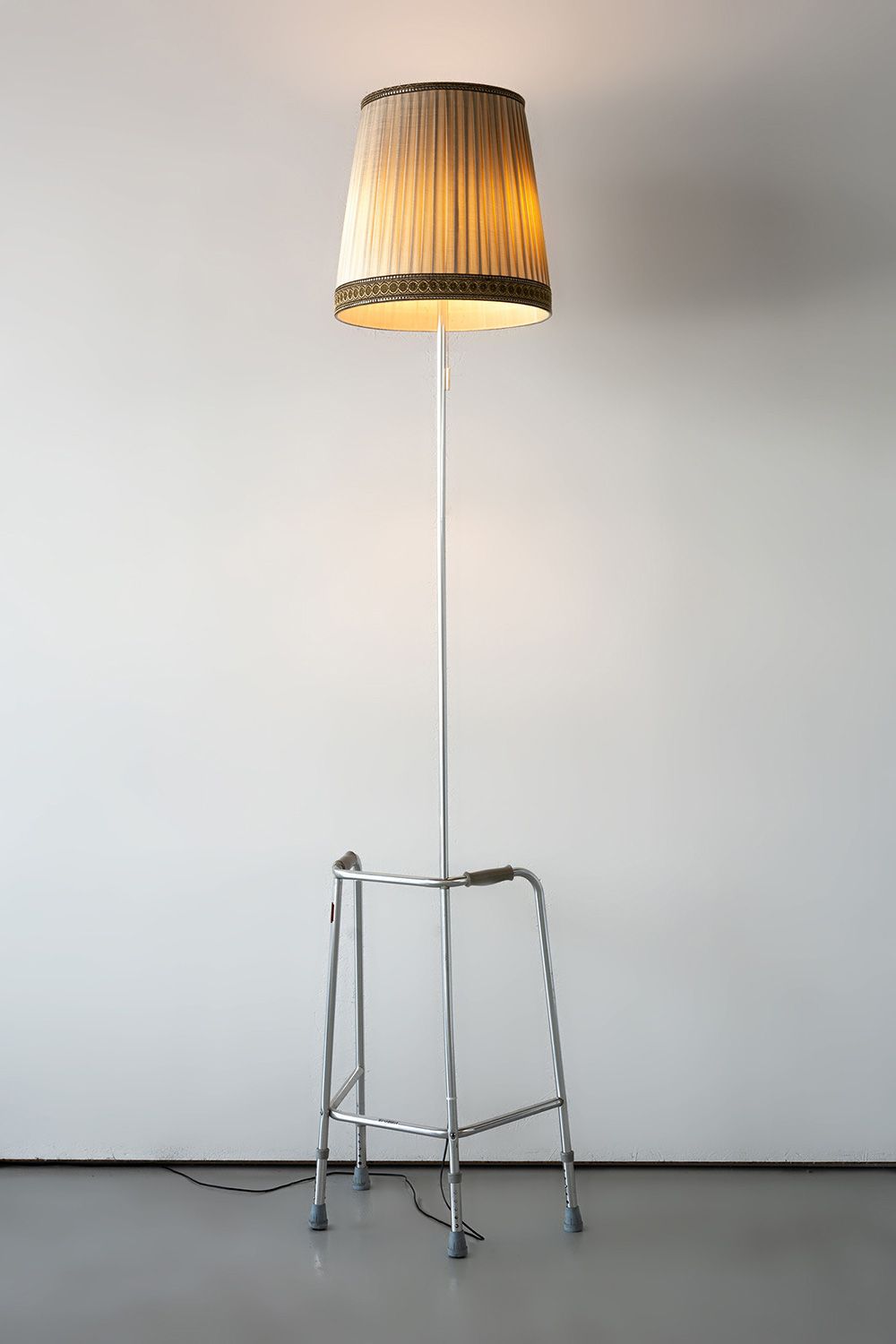 Always Stand On The Bright Side Of Life, 2019 Steel walker, pipe extension, lamp shade, light bulbs