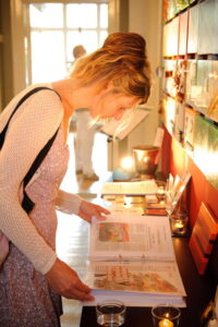 Besucherin liest in der Werkliste an einem Galerietresen