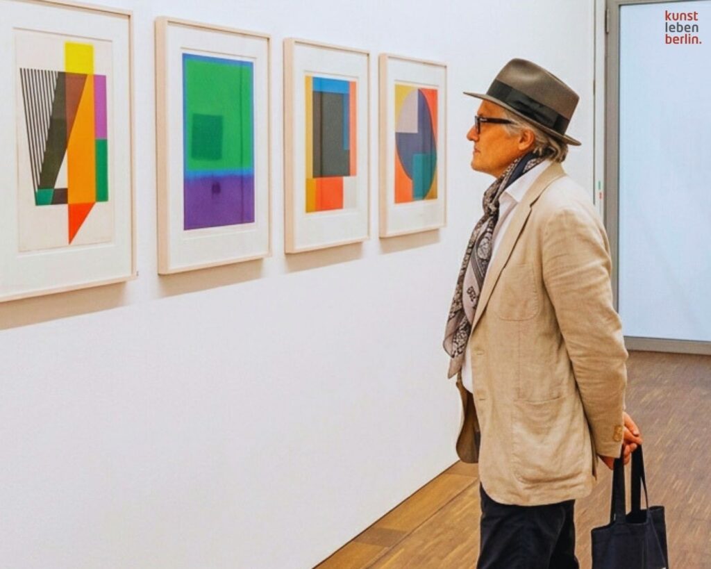 Mann betrachtet farbige Editionen, ein Blick auf zeitgenössische Kunst Preise in einer Berliner Galerie