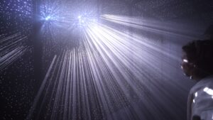Himmel unter Berlin: Lichtstrahlen fallen durch Nebel auf eine Besucherin im dunklen Kellergewölbe
