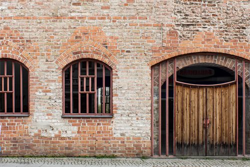 Galerie Gotisches Haus: Backsteinfassade mit Rundbogenfenstern und Holztor, Breite Straße 32, Spandau